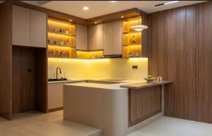 a kitchen with wooden cabinets and a kitchen island at Hendi Homestay E No 8 Puriloka1 in Batam Center