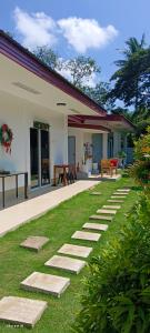a garden with stepping stones in front of a house at Ivorys Guesthouse in Panglao Island