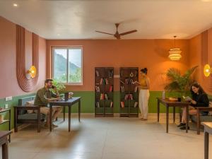 a group of people sitting at tables in a room at The Hosteller Kodaikanal in Kodaikānāl