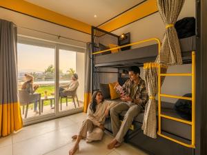 a group of people sitting in a room with bunk beds at The Hosteller Kodaikanal in Kodaikānāl