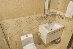 a bathroom with a toilet and a sink at Crystal Crown Hotel in Peshawar +27 photos
