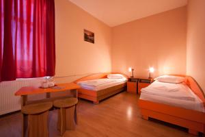 a hotel room with two beds and a table at Filo Hotel in Gheorgheni