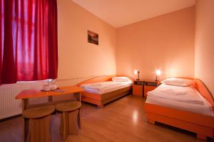 um quarto de hotel com duas camas e uma mesa em Filo Hotel em Gheorgheni