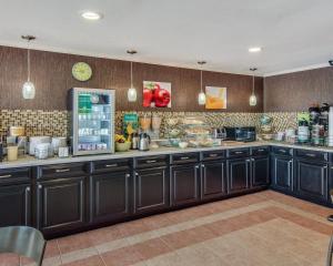 a kitchen with black cabinets and a refrigerator at Quality Inn Mt Pleasant in Mount Pleasant