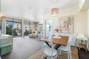 a kitchen and living room with a table and chairs at Spacious Darwin Esplanade Retreat with Pool & Spa in Darwin