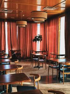 a dining room with wooden tables and red curtains at The Cabins at East Austin Hotel in Austin