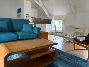 a living room with a blue couch and a table at The Hayloft, Noss Mayo in Plymouth