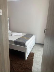 a white bed in a room with a door at Edwin homes in Nairobi