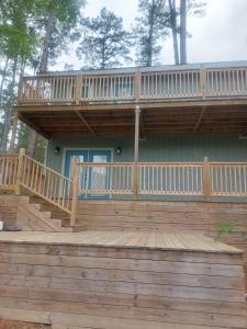 a deck with a balcony on top of a house at Big Bass Bungalow - Quitman Tx in Quitman