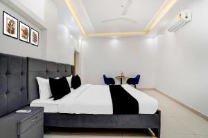 a bedroom with a black and white bed and a table at Hotel O Jaimantri Palace in Bihār Sharīf