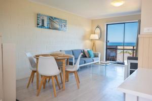 a living room with a table and chairs and a couch at Blue Seas Holiday Villas in Scamander +108 photos