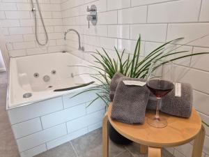 a bathroom with a table with a glass of wine at Finchy Cottage in Beechworth +6 photos