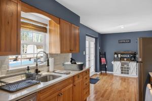 a kitchen with wooden cabinets and a sink at Summit Chalet at Stillwater in Pocono Summit