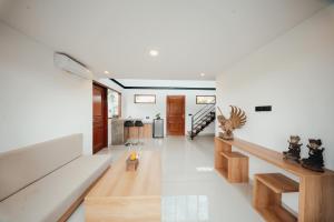 a living room with white walls and wooden floors at The Solas Villa Ubud in Ubud