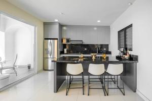 a kitchen with a black counter and white appliances at Mar y Sol 15th Floor 3BR 2 BA Condo with pool in Rosarito