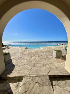 a large stone patio with the ocean in the background at Mar y Sol 15th Floor 3BR 2 BA Condo with pool in Rosarito +22 photos