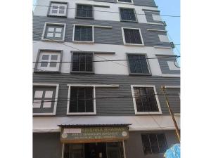 a tall white building with a sign in front of it at Hotel O Krishna Bhawan in kolkata