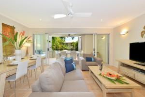 a living room with a couch and a table at Cayman Villas Port Douglas in Port Douglas