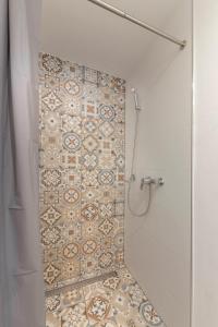 a bathroom with a shower with a tile wall at New Apartments Škofije Ankaran in Koper
