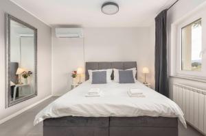a bedroom with a large bed with two towels on it at New Apartments Škofije Ankaran in Koper