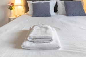 a pile of towels sitting on a white bed at New Apartments Škofije Ankaran in Koper