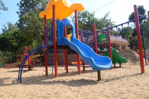 a playground with a slide in the sand at Upasana Retreat in Kalasa