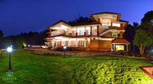 a large house with a green yard at night at Upasana Retreat in Kalasa