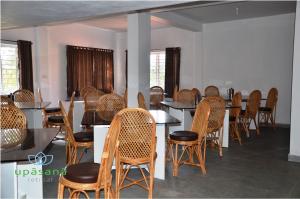 a dining room with tables and chairs and windows at Upasana Retreat in Kalasa +70 photos