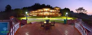 a large house with a table and chairs in front of it at Upasana Retreat in Kalasa
