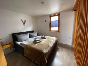 a bedroom with a bed with a table and a window at Deer Lounge in Bad Liebenstein