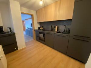a kitchen with gray cabinets and a wooden floor at Deer Lounge in Bad Liebenstein