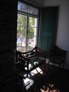 a window with a bench and a chair in a room at Hotel Pousada Hospedaria Antiga in Ouro Preto