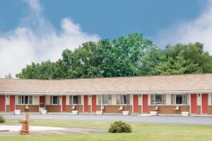 un edificio rosso con un idrante di fronte di Budget Inn Mifflintown a Mifflintown