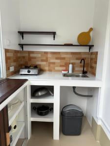 a kitchen with a white counter and a sink at Ivorys Guesthouse in Panglao Island +7 photos