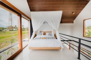 a bedroom with a canopy bed and a window at The Solas Villa Ubud in Ubud +45 photos