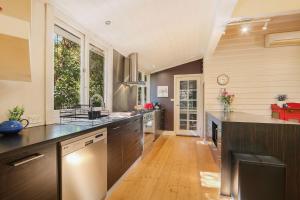 a large kitchen with wooden flooring and brown cabinets at Marianna's Lakeside Cottage in Beechworth +21 photos