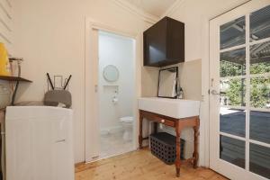 a bathroom with a sink and a toilet and a mirror at Marianna's Lakeside Cottage in Beechworth