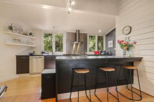 a kitchen with a counter with stools in it at Marianna's Lakeside Cottage in Beechworth