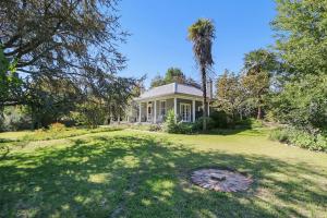 a house with a palm tree and a large yard at Marianna's Lakeside Cottage in Beechworth
