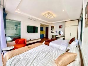 a bedroom with two beds and a flat screen tv at Time Villa in Tam Ðảo