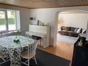 a living room with a table and a piano at Österlen - Gathus in Onslunda in Onslunda