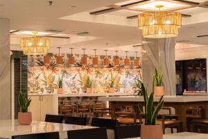 a restaurant with tables and chairs and potted plants at Castillo Real St Augustine Beach,Tapestry Collection Hilton in Saint Augustine Beach