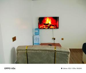 a room with a tv on a wall with a couch at Marine waters retreat Block A in Embu