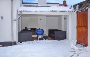 a house with a blue vase in the snow at 3 Bedroom Nice Home In Simrishamn in Simrishamn