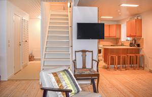 a living room with a ladder and a chair and a kitchen at 3 Bedroom Nice Home In Simrishamn in Simrishamn