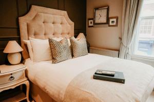 ein Schlafzimmer mit einem großen Bett und einer Uhr an der Wand in der Unterkunft The Boot at Melbourne in Derby
