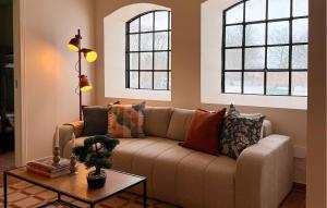 a living room with a couch and two windows at 2 Bedroom Nice Apartment In Glemmingebro in Glemminge
