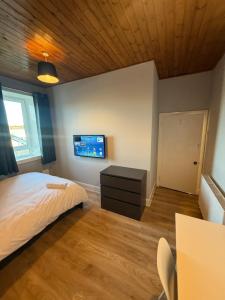 ein Schlafzimmer mit einem Bett und einem Fernseher an der Wand in der Unterkunft Peterhead contractor accommodation in Peterhead + 4 Fotos