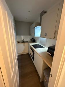 eine Küche mit weißen Schränken und einer Arbeitsplatte in der Unterkunft Peterhead contractor accommodation in Peterhead