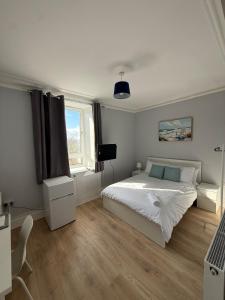 ein weißes Schlafzimmer mit einem Bett und einem Fenster in der Unterkunft Peterhead contractor accommodation in Peterhead